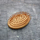 A close-up of the travel brush's soft bristles and scalp massage function.